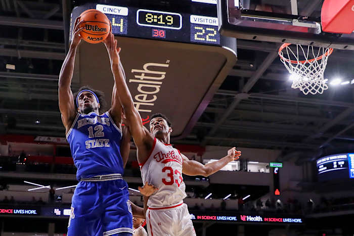 Jan 22, 2023; Cincinnati, Ohio, USA; Memphis Tigers forward DeAndre Williams (12) battles for the ball against Cincinnati Bearcats forward Ody Oguama (33) in the first half at Fifth Third Arena. Mandatory Credit: Katie Stratman-USA TODAY Sports